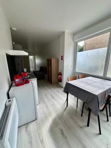 cocina y sala de estar con mesa y ventana en 001 T2 Immeuble Persévérance, en Conflans-en-Jarnisy