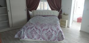 ein Schlafzimmer mit einem Bett mit einer lila Bettdecke in der Unterkunft Vila Flory Voronet in Woronetz