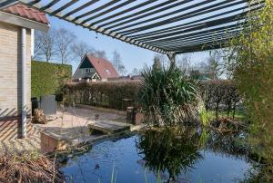 una piscina d'acqua in un cortile con pergolato di Wellnesshuis Drenthe a Schoonloo
