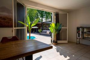 un soggiorno con tavolo e una grande finestra di Wellnesshuis Drenthe a Schoonloo