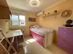 a small room with a bed and a desk at Bungalow on the beach 15 minutes from Valencia in Valencia