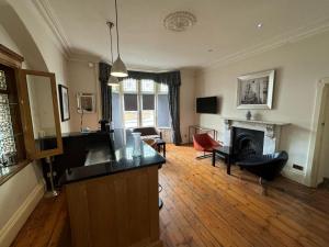 a living room with a kitchen and a fireplace at Taunton Town House in Taunton
