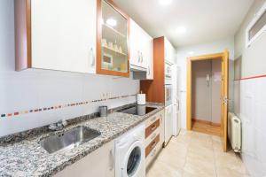 een keuken met een wastafel en een wasmachine bij Apartamento GO Felipe II Center in Valladolid