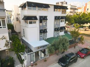 una vista aérea de un edificio blanco con coches aparcados fuera en Magesa Homes, en Antalya