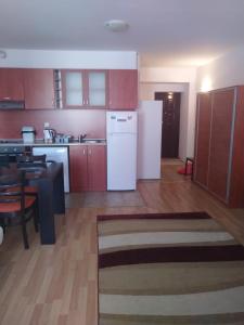 uma cozinha com armários vermelhos e um frigorífico branco em Guest House Kami em Byala