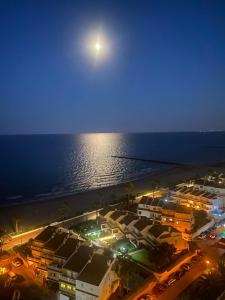 a view of a beach at night with a full moon at Bungalow on the beach 15 minutes from Valencia in Valencia