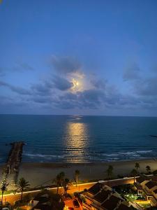 a view of the ocean at night with a full moon at Bungalow on the beach 15 minutes from Valencia in Valencia