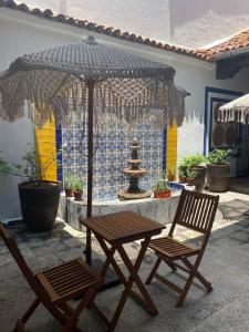 une table, deux chaises, une table et un parasol dans l'établissement PASEO REAL HOTEL BOUTIQUE, à Uruapan del Progreso