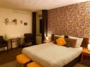 ein Schlafzimmer mit einem Bett und einer Ziegelwand in der Unterkunft Gasterij Hotel Dennenoord in Boxtel