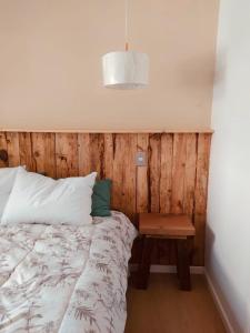 a bedroom with a bed and a wooden wall at Cabaña céntrica en Temuco in Temuco