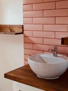 a bathroom with a white sink and a brick wall at Cabaña céntrica en Temuco in Temuco