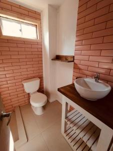 a bathroom with a white toilet and a sink at Cabaña céntrica en Temuco in Temuco