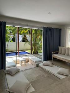 a living room with a couch and a large window at La Réserve Villa REPOUSO PARAISO in Pipa