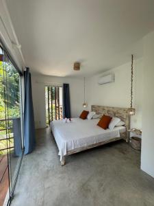 a bedroom with a bed and a large window at La Réserve Villa REPOUSO PARAISO in Pipa