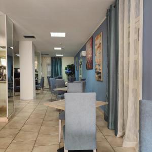 ein Esszimmer mit Tischen und Stühlen und blauen Wänden in der Unterkunft Hotel Sirio in Reggio di Calabria