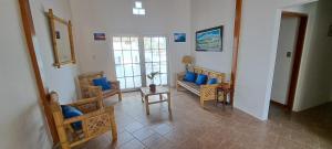 a living room with blue pillows and chairs at Las Fragatas Casa Hotel Eventos para 40 personas in Canoas de Punta Sal