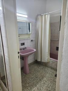 y baño con lavabo rosa y ducha. en Casa Verde en Centenario