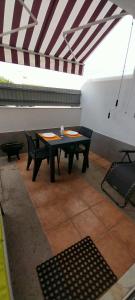 eine Terrasse mit einem Tisch und Stühlen in einem Zimmer in der Unterkunft Chez Rosa in Vila Real de Santo António