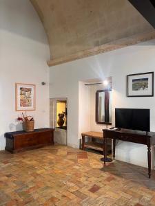 a living room with a piano and a television at Hotel San Giorgio in Matera