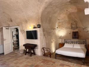 a bedroom with a bed and a tv and a table at Hotel San Giorgio in Matera