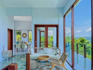 セロング・ベラナクにあるOcean Wave Lombok - 4 BR infinity pool villaのリビングルーム(テーブル、椅子付)