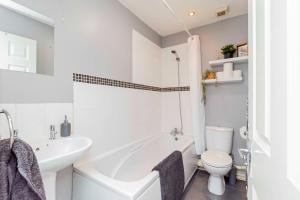 a bathroom with a tub and a toilet and a sink at Eastleigh Serviced Apartment in Chandlers Ford