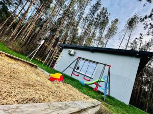 a small house with a playground in the grass at 4REST in Żytno