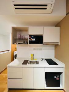 cocina blanca con fregadero y microondas en City suites colony by infinitum Klcc, en Kuala Lumpur