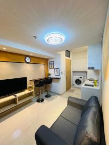 sala de estar con sofá y TV de pantalla plana en City suites colony by infinitum Klcc, en Kuala Lumpur
