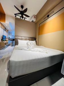 1 dormitorio con 1 cama blanca grande y ventilador de techo en City suites colony by infinitum Klcc, en Kuala Lumpur