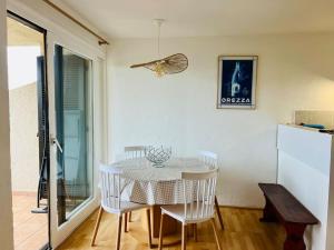 een eetkamer met een tafel en witte stoelen bij Appartement T2 vue mer in Porticcio