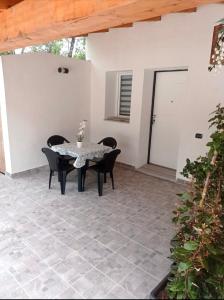 a patio with a table and chairs and a door at Case vacanze Rosa in Siniscola