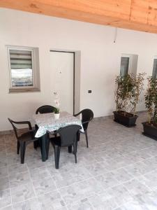 a patio with a table and chairs on a tile floor at Case vacanze Rosa in Siniscola