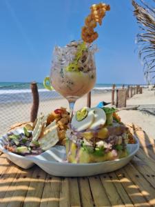 a plate of food with a drink on the beach at Las Fragatas Casa Hotel Eventos para 40 personas in Canoas de Punta Sal