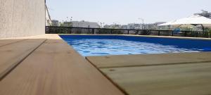 - une piscine d'eau bleue au-dessus d'un bâtiment dans l'établissement royal vila netivot, à Netivot