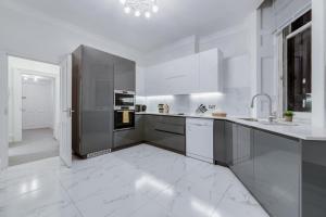 una cocina con electrodomésticos blancos y un gran suelo de baldosa blanca. en Harley Street Spectacular Suites with High Ceilings, High Luxury, en Londres