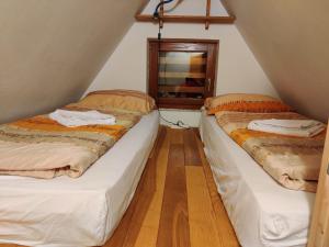 two beds in a small room with a window at Apartmani Nono in Jahorina
