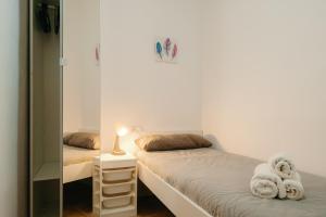 Habitación pequeña con 2 camas y espejo. en Apartamento Céntrico, en Tarragona