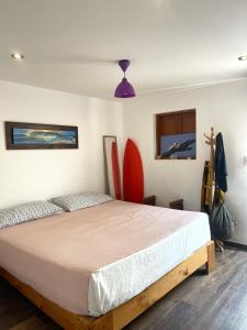 a bedroom with a bed with surfboards on the wall at El Templo Surf House in Punta Hermosa