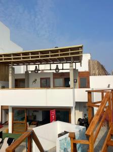 a large white building with awning on top of it at El Templo Surf House in Punta Hermosa