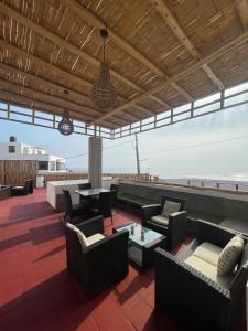 a patio with couches and tables on a roof at El Templo Surf House in Punta Hermosa