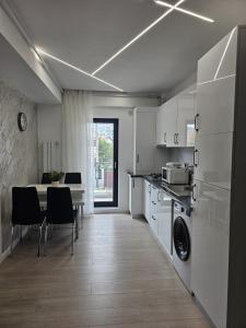 a kitchen and dining room with a table and chairs at Apartamentul cu amintiri in Mamaia Nord