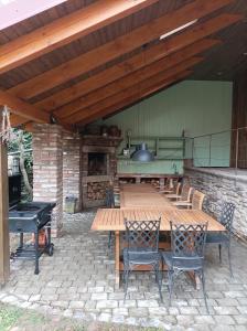 un patio con mesa de madera, sillas y chimenea en Apartmán Na statku en Miskovice