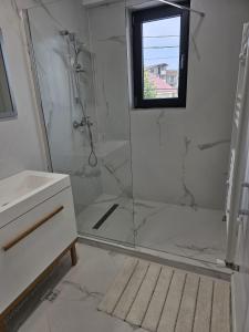 a bathroom with a shower and a sink and a window at Apartamentul cu amintiri in Mamaia Nord +11 photos