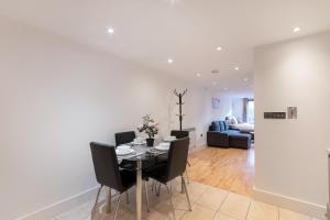 a dining room and living room with a table and chairs at Charming Studio Flat in Kingston KT2, London in Kingston upon Thames