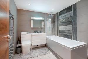 uma casa de banho com uma banheira, um lavatório e um WC. em Charming Studio Flat in Kingston KT2, London em Kingston upon Thames