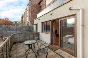 a patio with a table and chairs on a balcony at Charming Studio Flat in Kingston KT2, London in Kingston upon Thames