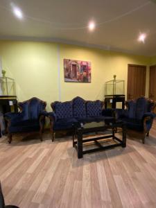 a waiting room with three blue couches and chairs at Siqvaruli in Tbilisi City
