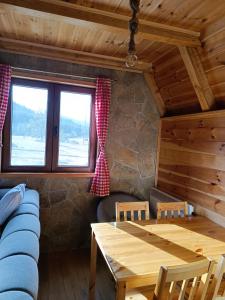 uma sala de estar com uma mesa e um sofá em Zabljak_vikendica em Žabljak