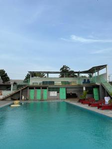 uma grande piscina com água azul e cadeiras vermelhas em SEGMAD HOTEL em Kribi